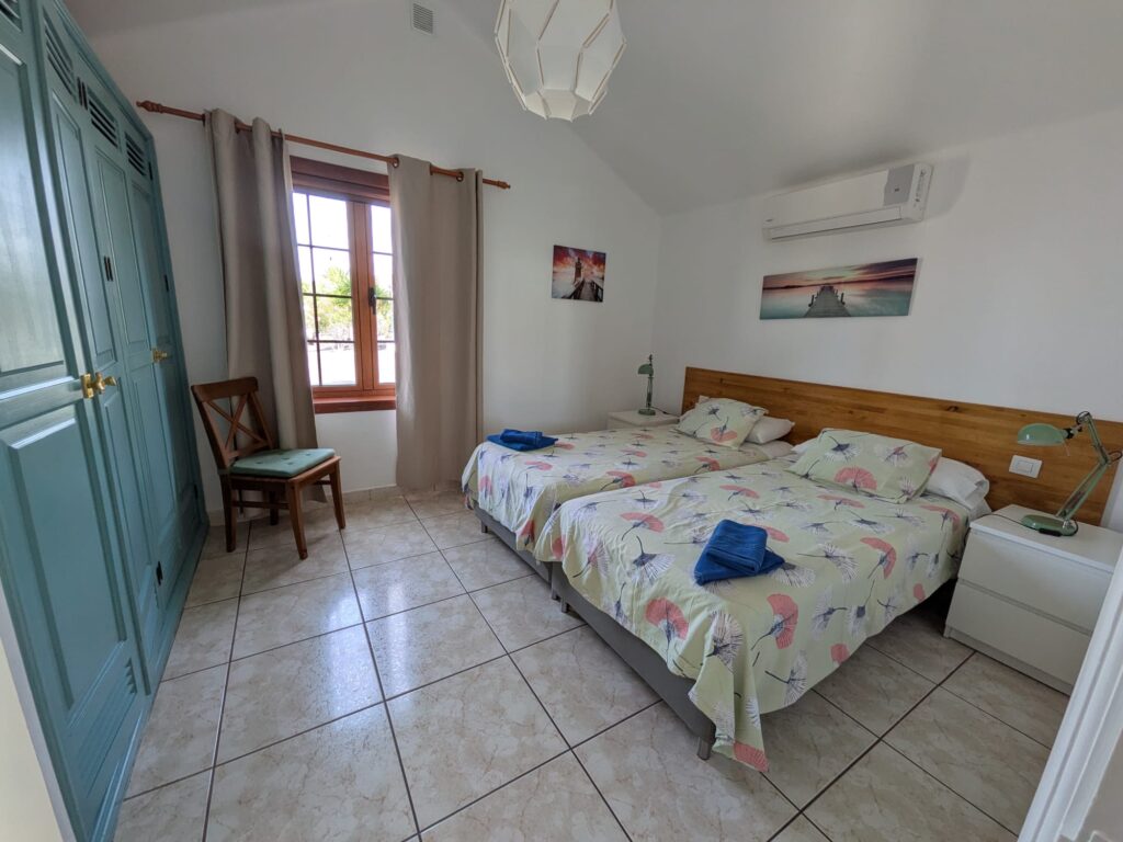 Habitación luminosa con cama doble, armario y vista a la ventana.