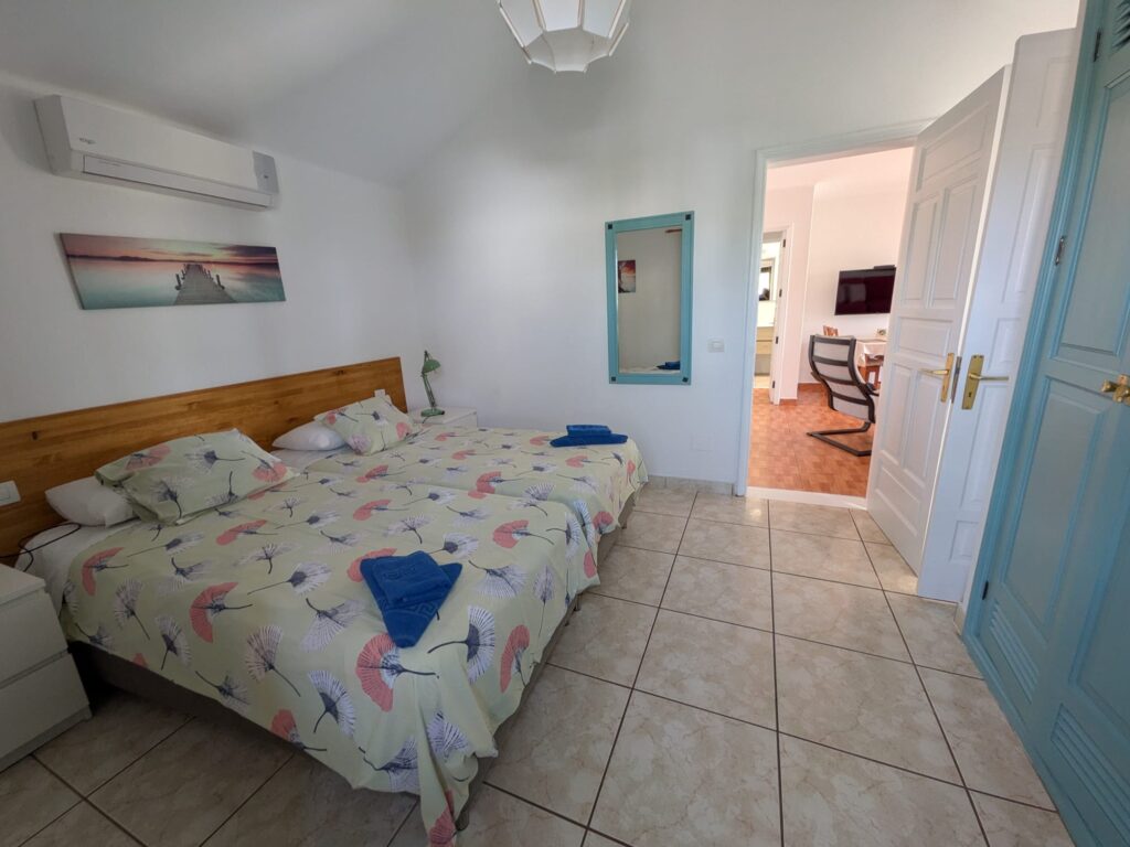 Habitación doble con cama grande, aire acondicionado y decoración moderna.