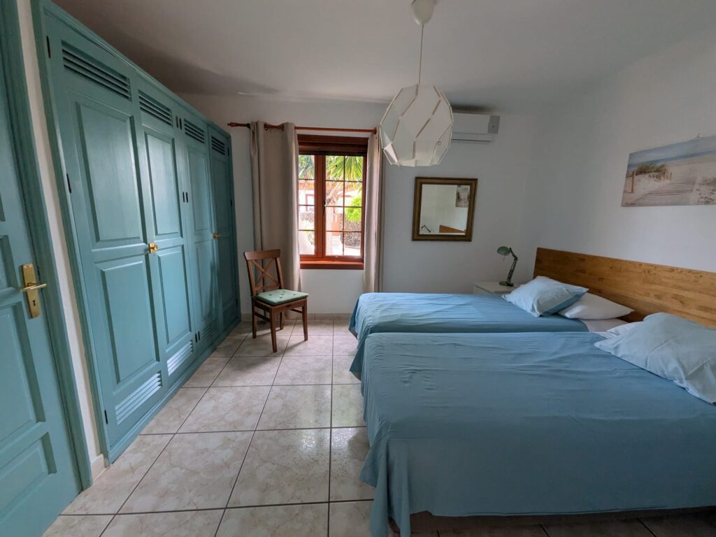 Habitación con dos camas, armario grande y vista a la ventana en Casas del Sol.