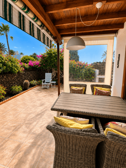 Casa del Sol terrace with furniture and views of the garden and the sea in a tropical setting.