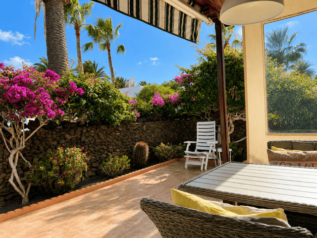 Outdoor terrace with furniture, tropical plants and shade in Casas del Sol.